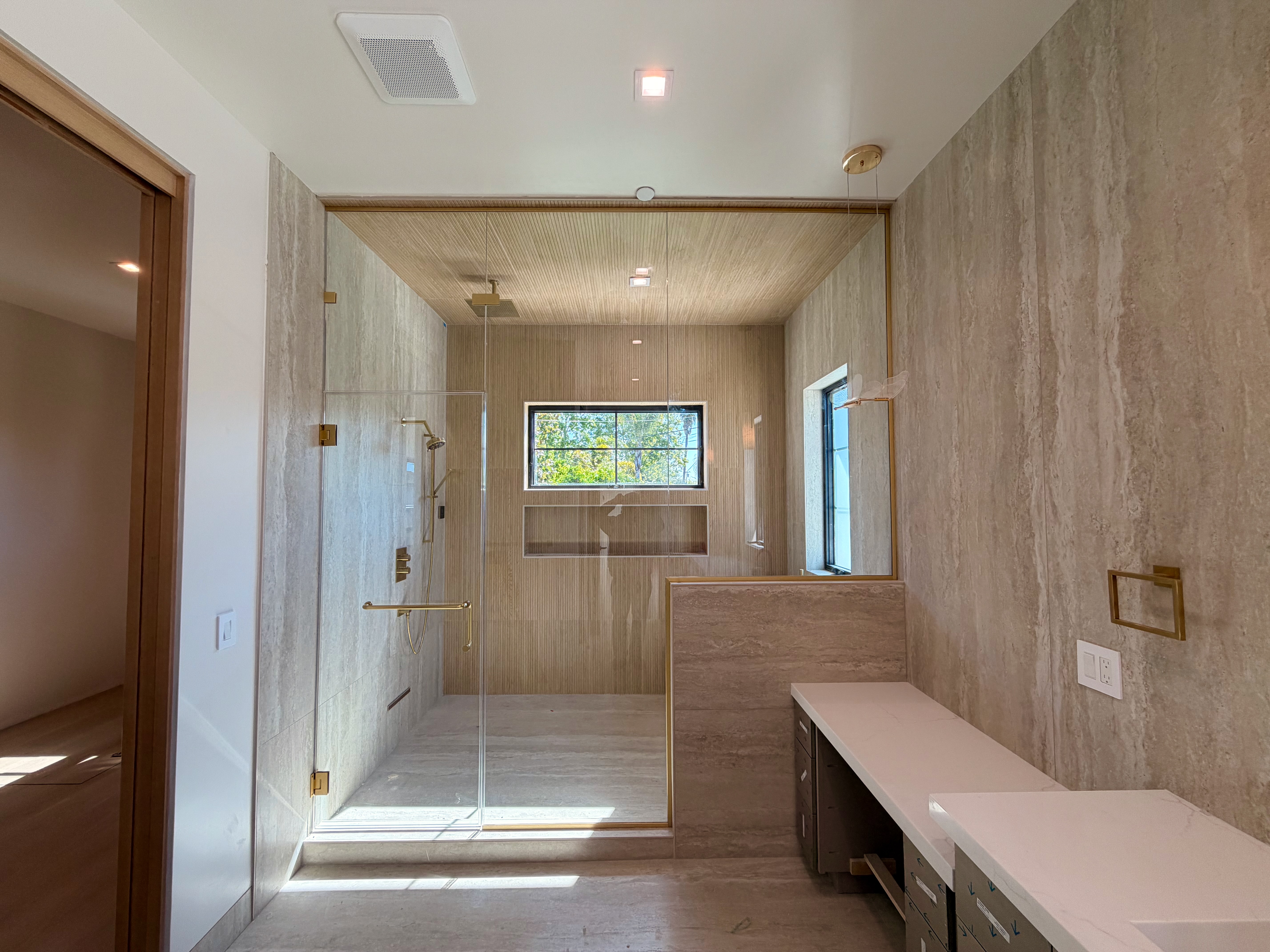 Custom frameless shower enclosure with gold hardware