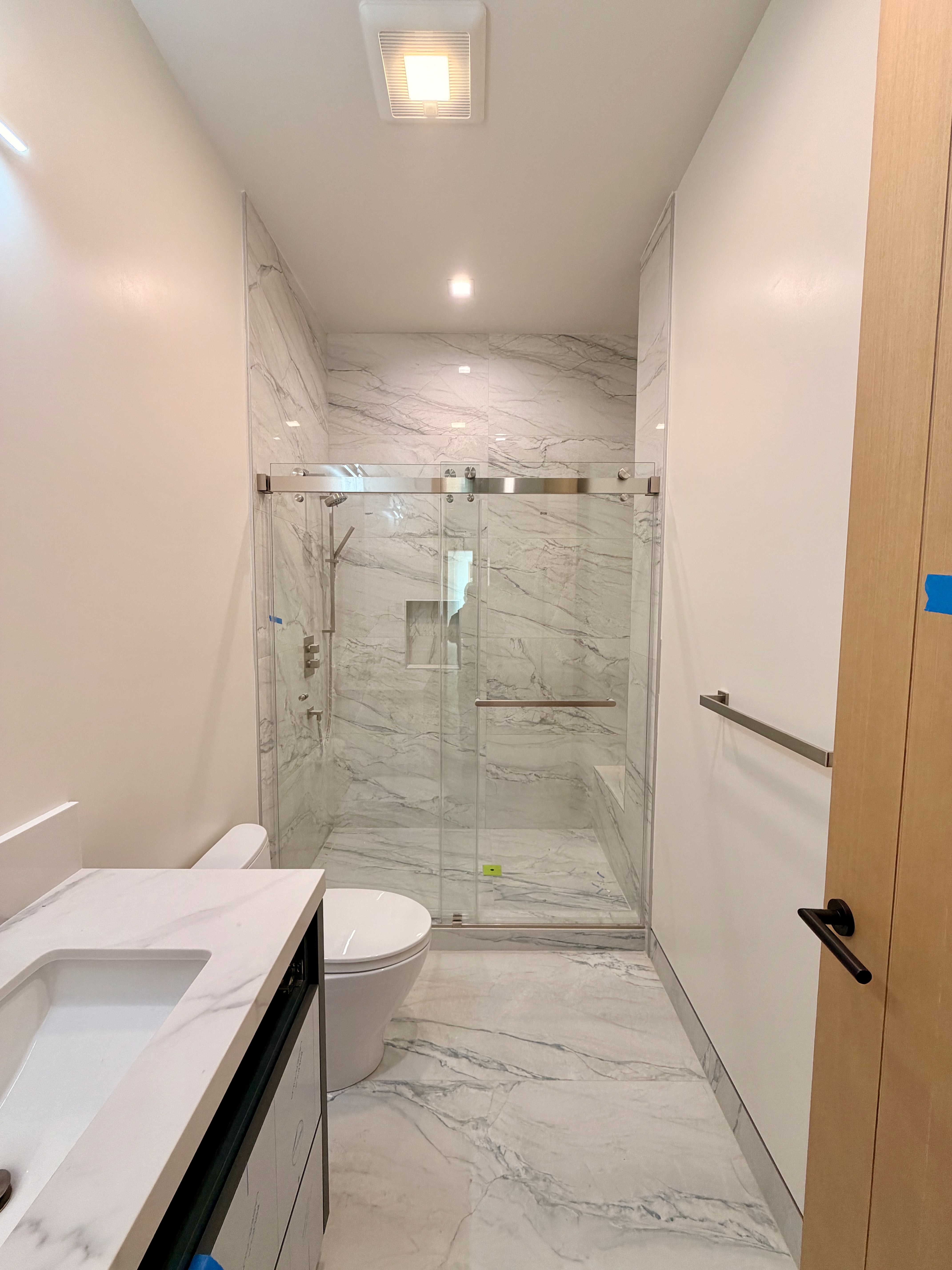 Sliding glass shower door with marble walls