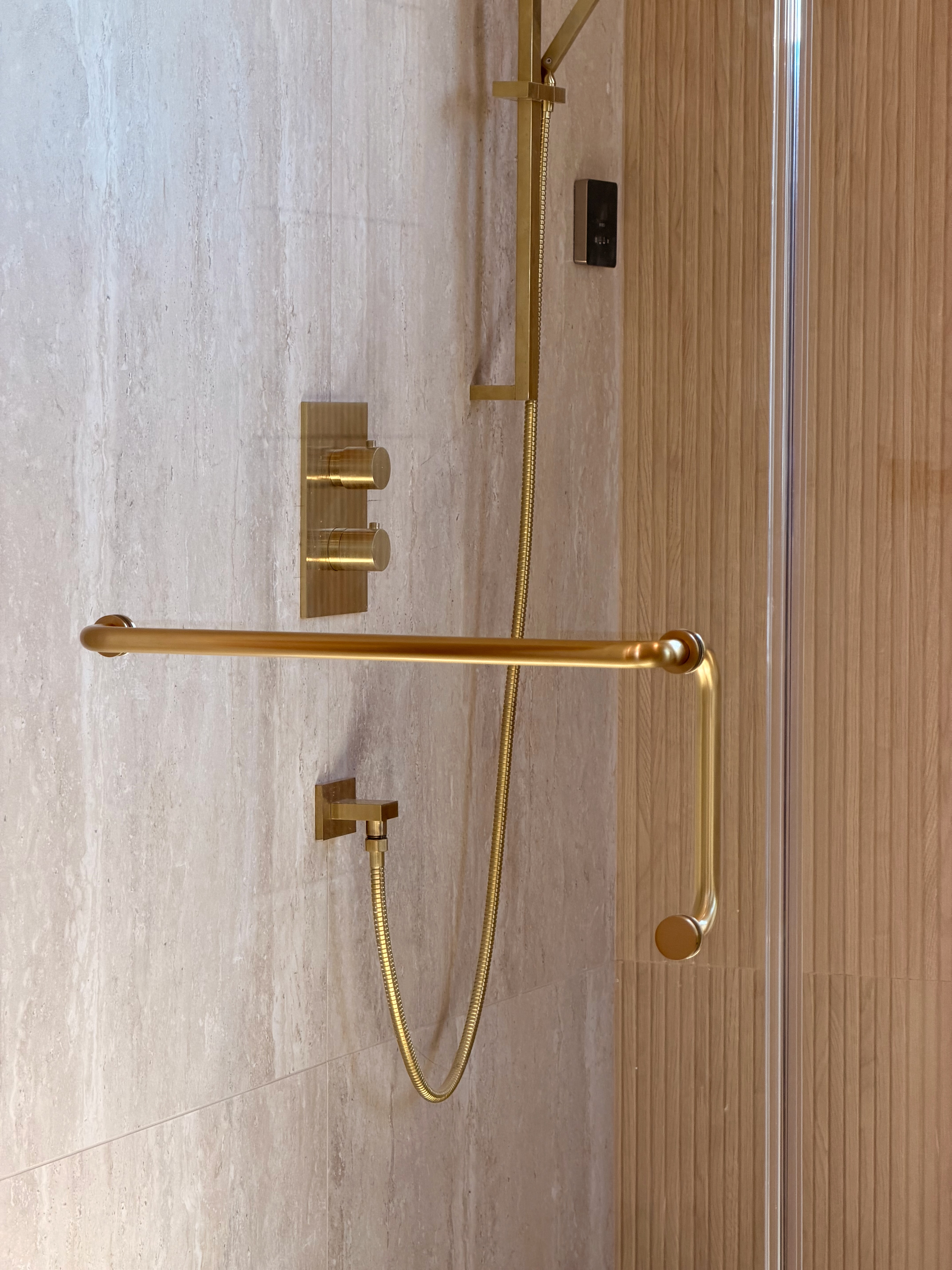 Elegant frameless shower enclosure with matching gold hardware